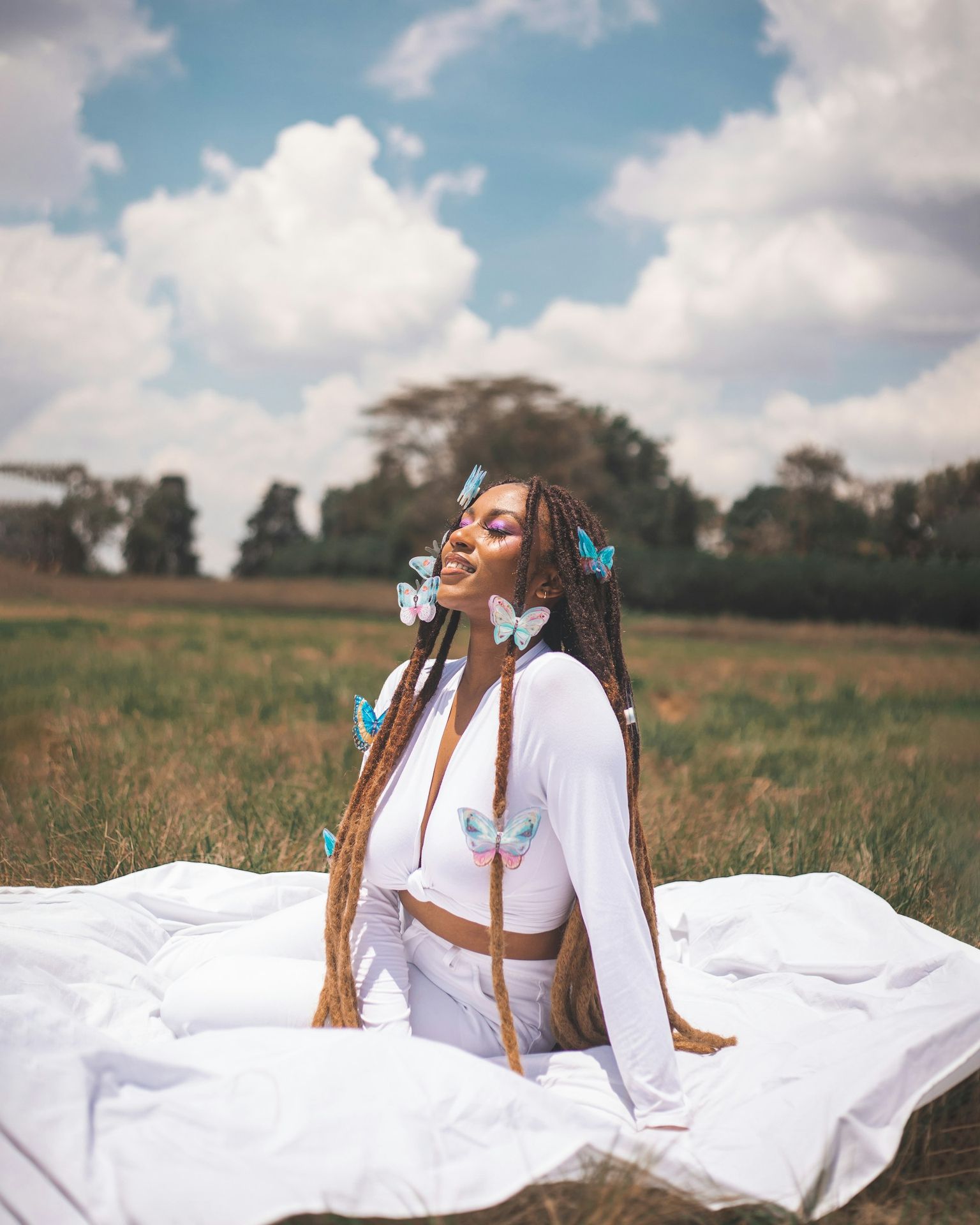 A woman sitting on a blanket in a field